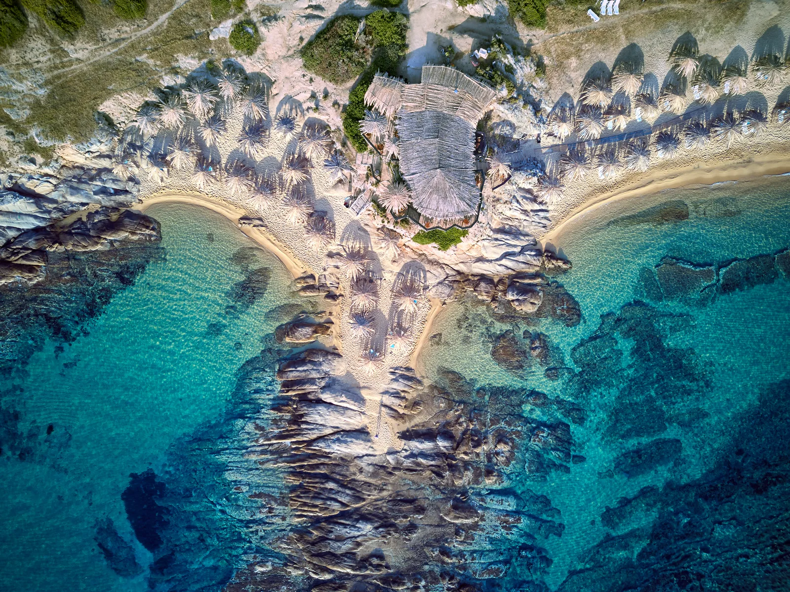 O costão separa duas praias e cria o canto abrigado. É também onde a corrente de retorno costuma correr.