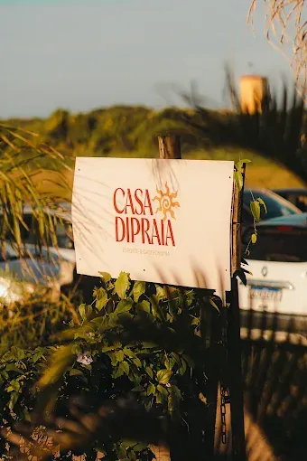 Placa de entrada do Casa diPraia no fim da tarde