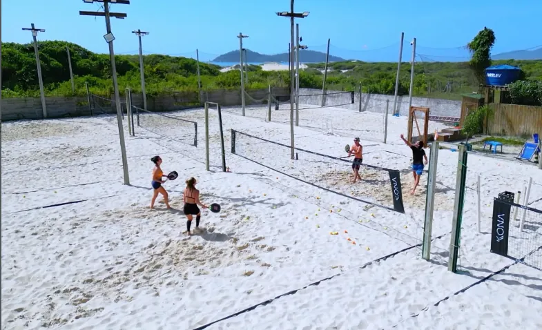 Quadras de beach tennis do Casa diPraia, com o mar ao fundo