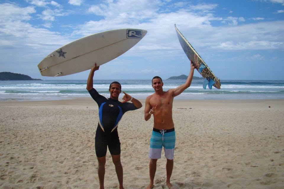 Dois surfistas com as pranchas na cabeça