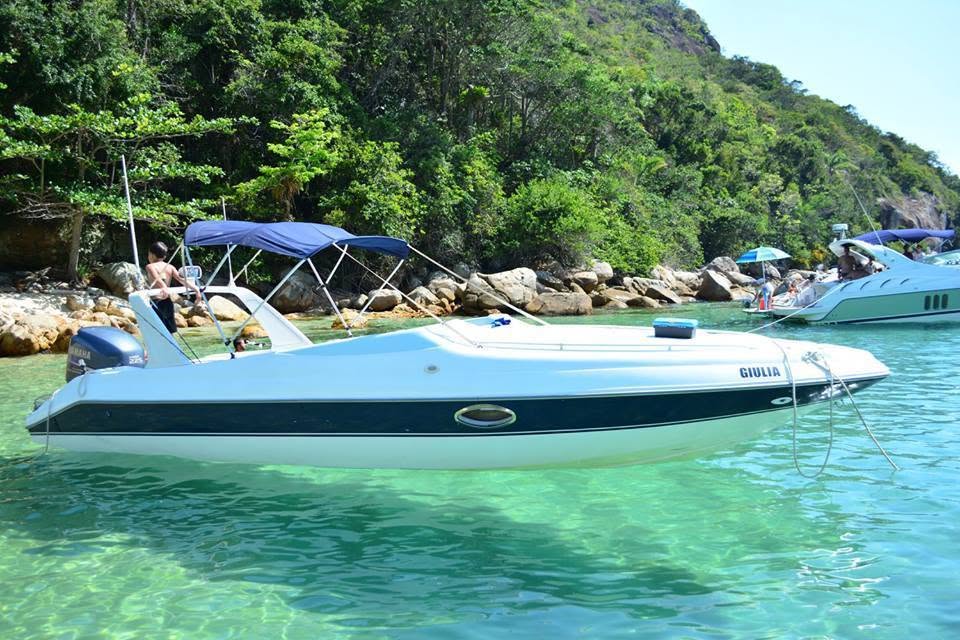 Lancha parada na água verde da Lagoa Azul