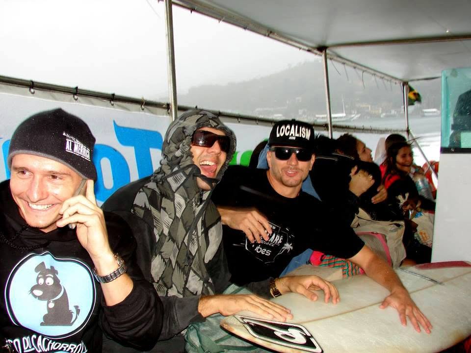 Pranchas e surfistas a bordo, com a ilha se aproximando